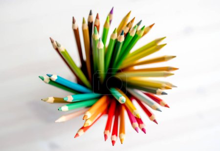 Foto de Lápices de colores agudos en papel acuarela, vista desde arriba. Paleta de crayones multicolor para inspiración artística - Imagen libre de derechos