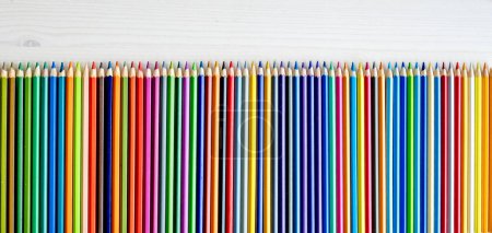 Téléchargez les photos : Colorful pencils lying on watercolor paper closeup. Multicolor crayons pallete for artist inspiration and hobby - en image libre de droit