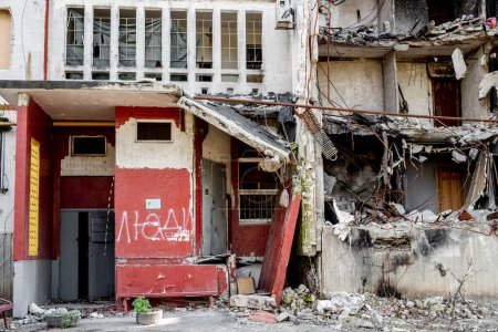 Zerstörtes Gebäude nach russischem Raketenangriff im Krieg in der Ukraine. Hausruinen mit Wort Menschen in Wohnviertel in der Stadt Charkiw