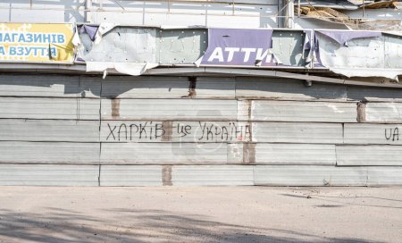 Téléchargez les photos : Lettres Kharkiv est l'Ukraine au mur de construction détruit après l'invasion de la Russie pendant la guerre. Ruines abandonnées après russian missle fusée attaque - en image libre de droit
