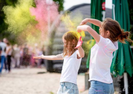 Photo for Pretty sisters in indian traditional Holi festival with colorful powder having fun. Female teenager and preteen child friends enjoying holiday - Royalty Free Image