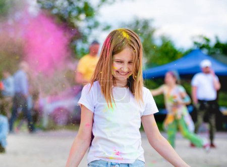 Photo for Preteen girl in indian traditional Holi festival with colorful powder having fun. Female child kid enjoying positive holiday of India - Royalty Free Image