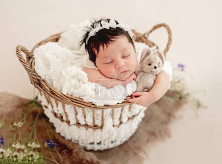 Téléchargez les photos : Drôle de nouveau-né dormir dans le panier sur le ventre - en image libre de droit