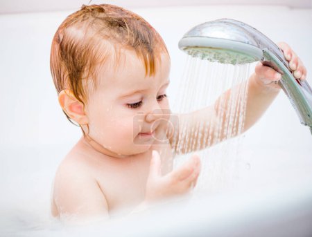 Foto de Linda chica de 1 año se baña en una ducha - Imagen libre de derechos