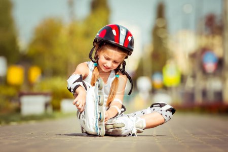 Téléchargez les photos : Peu mignon heureux petite fille mettre des rouleaux - en image libre de droit