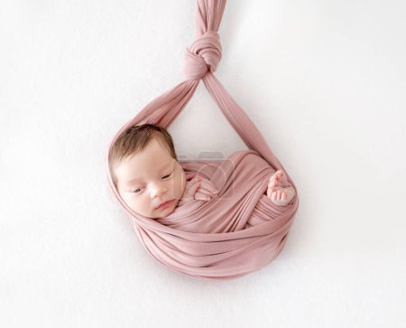 Photo for Adorable newborn baby girl sleeping in hammock portrait. Cute infant child kid swaddled in fabric resting in swing - Royalty Free Image