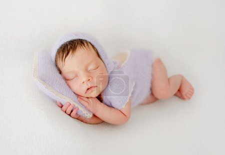 Photo for Adorable newborn baby girl sleeping on pillow. Cute infant child kid in knitted dress napping lying on tummy - Royalty Free Image