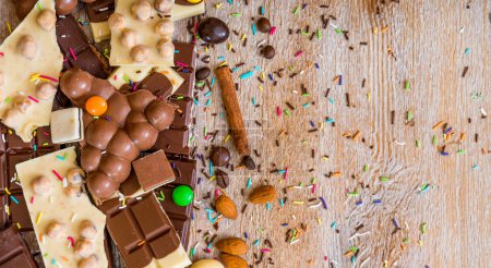 Téléchargez les photos : Chocolat et bonbons sur un fond en bois - en image libre de droit