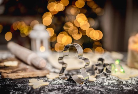 Foto de Conjunto para hacer pan de jengibre en la mesa frente al árbol de Navidad - Imagen libre de derechos