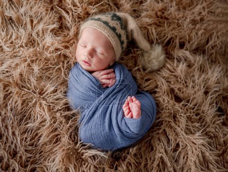 Photo for Adorable newborn baby boy smiling during sleeping and holding knitted giraffe toy. Cute infant child kid napping on fur - Royalty Free Image