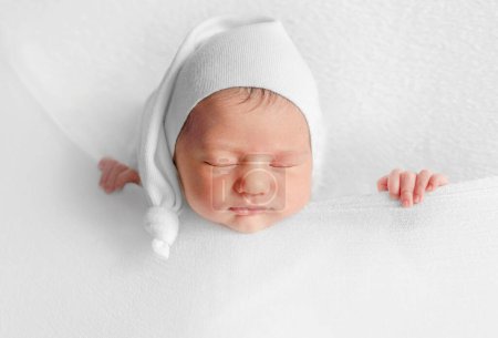 Téléchargez les photos : Fille nouveau-né dort sous la couverture pendant la séance photo infantile en studio - en image libre de droit