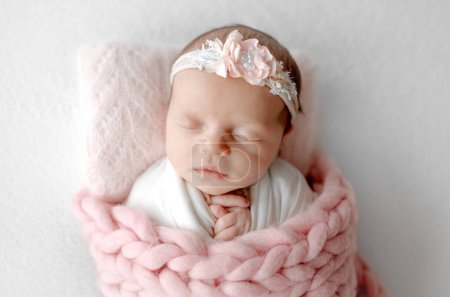 Téléchargez les photos : Bébé fille dort sous la couverture avec bandeau dans la séance photo nouveau-né au studio - en image libre de droit