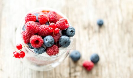 Photo for Dessert from yogurt with chia seeds, raspberries and blueberries on a old wooden background. top view - Royalty Free Image