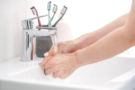 Foto de Las manos femeninas bajo el agua se lavan con jabón - Imagen libre de derechos