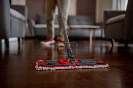 Photo for Woman Mops Floor With Mop In Room, Close Up - Royalty Free Image