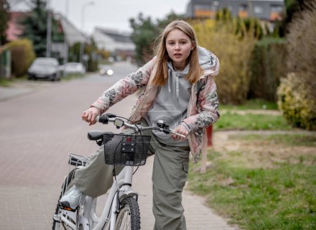 Téléchargez les photos : Fille monte à vélo parmi les maisons privées en Europe au printemps - en image libre de droit