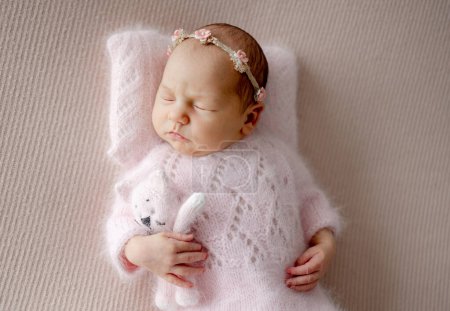 Téléchargez les photos : Fille nouveau-né en costume rose dort avec chat jouet pendant Photoshoot nouveau-né professionnel - en image libre de droit