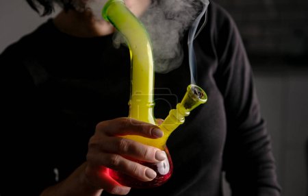 Frau raucht Marihuana mit Bong in Nahaufnahme und repräsentiert Lifestyle-Konzepte und weltweite Legalisierung von Marihuana
