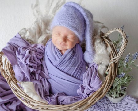 Téléchargez les photos : Le nouveau-né enveloppé dans de la lavande dort dans un panier pendant une séance photo en studio - en image libre de droit