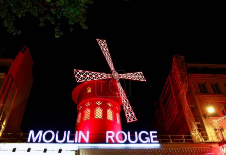 Foto de París / Francia - 30 de abril de 2017: vista del Moulin Rouge (molino rojo) por la noche en París, un cabaret de punto de referencia en el barrio de Montmartre de la capital francesa. - Imagen libre de derechos