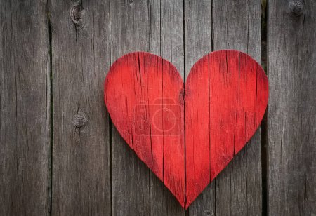 Coeur rouge vif comme symbole d'amour et d'amitié sur le fond en bois