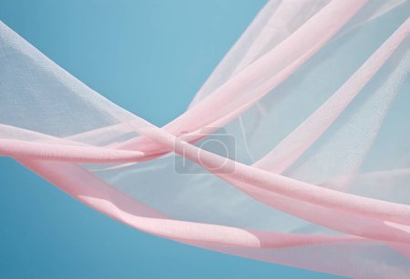 Téléchargez les photos : Volant vague de tissu transparent rose sur fond bleu et illuminé par la lumière du soleil, ondulant tissu flottant de soie - en image libre de droit