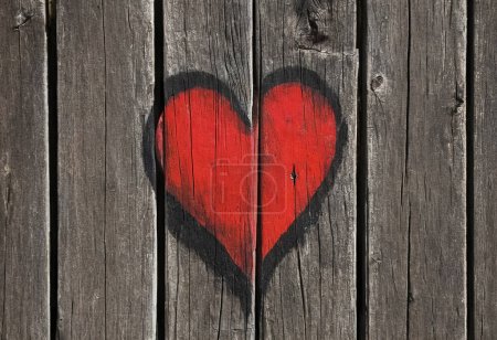 Coeur rouge vif comme symbole d'amour dessiné sur un fond vintage en bois