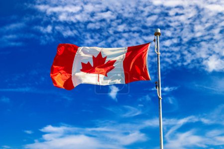 Téléchargez les photos : Drapeau canadien agitant contre le ciel bleu par une journée ensoleillée, Canada - en image libre de droit