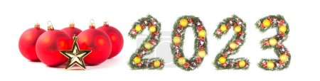 Foto de Bola roja de navidad y número 2023 hecha por ramas de árbol de navidad aisladas sobre fondo blanco - Imagen libre de derechos