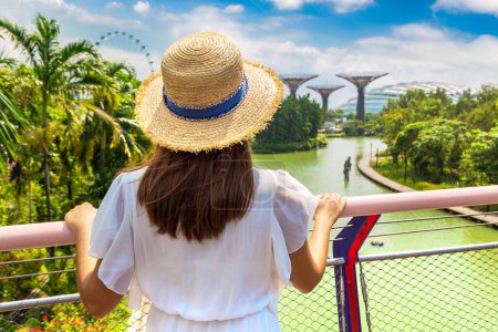 Foto de SINGAPUR - 23 de junio de 2019: Mujer viajera vestida de blanco y sombrero de paja en Gardens by the Bay en Singapur - Imagen libre de derechos
