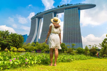 Photo for SINGAPORE, SINGAPORE - FEBRUARY 26, 2020: Woman traveler looking at Marina Bay Sands Hotel  in Singapore - Royalty Free Image