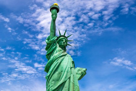 Téléchargez les photos : Statue de la Liberté contre le ciel bleu avec un beau fond nuageux à New York, NY, USA - en image libre de droit