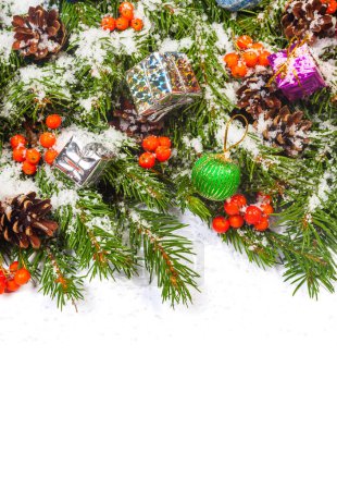 Téléchargez les photos : Fond de Noël avec boules et décorations et neige, baie de houx, cônes isolés sur blanc - en image libre de droit