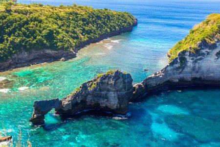 Téléchargez les photos : Arc rocheux naturel dans l'eau de mer et le belvédère d'Atuh Beach sur l'île de Nusa Penida, Bali, Indonésie - en image libre de droit