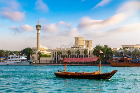 Photo for Abra - old traditional wooden boat and Al Farooq Mosque on the bay Creek in Dubai, United Arab Emirates - Royalty Free Image