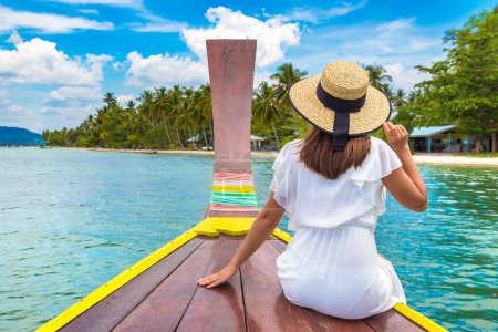 Téléchargez les photos : Joyeux voyageur femme relaxant sur le bateau près de l'île tropicale - en image libre de droit