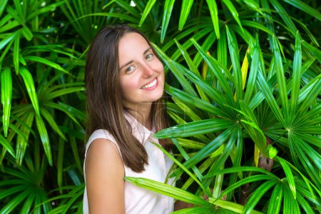Photo for Young beautiful woman  is posing among large leaves of tropical plant - Royalty Free Image