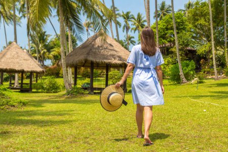 Téléchargez les photos : Femme voyageuse au Gazebo à Luxury tropical resort par une journée ensoleillée - en image libre de droit