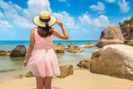 Téléchargez les photos : Femme voyageuse portant une robe rose et un chapeau de paille à Silver Beach sur l'île de Koh Samui, Thaïlande dans une journée d'été - en image libre de droit