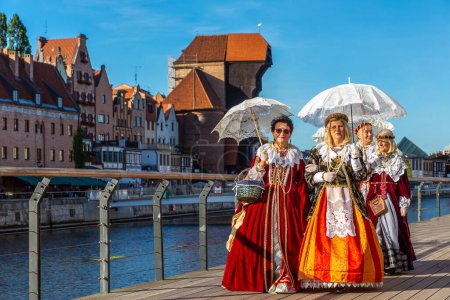 Photo for GDANSK, POLAND - SEPTEMBER 7, 2022: Group of women dressed in Polish national traditional folk dress in a beautiful old town in Gdansk, Poland - Royalty Free Image