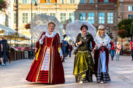 Téléchargez les photos : GDANSK, POLOGNE - 7 SEPTEMBRE 2022 : Groupe de femmes vêtues d'une robe folklorique nationale polonaise dans une belle vieille ville de Gdansk, Pologne - en image libre de droit