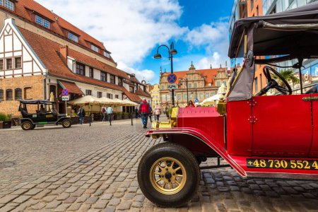 Foto de GDANSK, POLONIA - 7 DE SEPTIEMBRE DE 2022: Coche retro vintage para hacer turismo en un hermoso casco antiguo de Gdansk, Polonia - Imagen libre de derechos