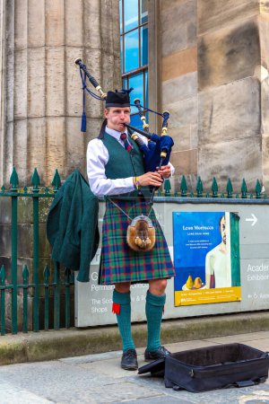 Téléchargez les photos : EDINBURGH, Royaume-Uni - 11 JUIN 2022 : Bagpiper jouant de la musique avec cornemuse près du château d'Édimbourg à Édimbourg, Écosse, Royaume-Uni - en image libre de droit