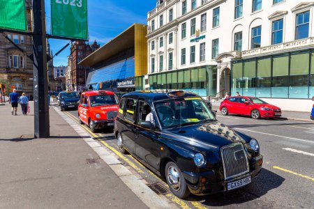 Téléchargez les photos : GLASGOW, Royaume-Uni - 14 JUIN 2022 : Une voiture de taxi noire lors d'une journée d'été à Glasgow, Écosse, Royaume-Uni - en image libre de droit