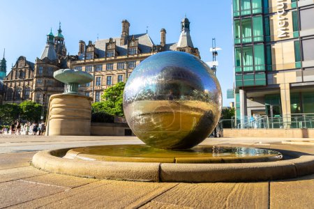 Photo for SHEFFIELD, UK - JUNE 16, 2022: The sculpture stainless steel spheres and Sheffield Town Hall in a sunny summer day in Sheffield, South Yorkshire, UK - Royalty Free Image