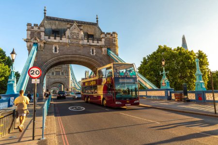 Foto de LONDRES, Reino Unido - 17 de junio de 2022: El histórico Puente de la Torre y las visitas turísticas de autobús de techo abierto BIGBUS en Londres al atardecer, Reino Unido - Imagen libre de derechos