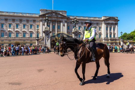 Téléchargez les photos : LONDRES, ROYAUME-UNI - 17 JUIN 2022 : La police à cheval métropolitaine patrouille lors du changement de garde devant Buckingham Palace à Londres par une journée ensoleillée d'été, Royaume-Uni - en image libre de droit