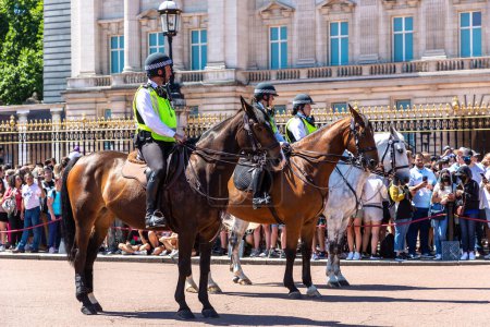 Téléchargez les photos : LONDRES, ROYAUME-UNI - 17 JUIN 2022 : La police à cheval métropolitaine patrouille lors du changement de garde devant Buckingham Palace à Londres par une journée ensoleillée d'été, Royaume-Uni - en image libre de droit