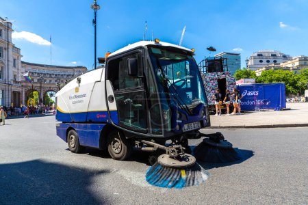 Foto de LONDRES, Reino Unido - 17 de junio de 2022: Vehículo de limpieza de calles que trabaja en una calle de Londres en un soleado día de verano, Reino Unido - Imagen libre de derechos