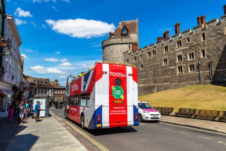 Téléchargez les photos : WINDSOR, Royaume-Uni - 19 JUIN 2022 : Bus Hop-on Hop-off TOOTbus près du château de Windsor à Windsor par une journée d'été ensoleillée, Royaume-Uni - en image libre de droit